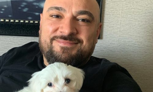 İsmail Polat Hayvan Sevgisi'nin .gösterildiği bu fotoğrafta elinde köpek tutan bir adam yer alır.